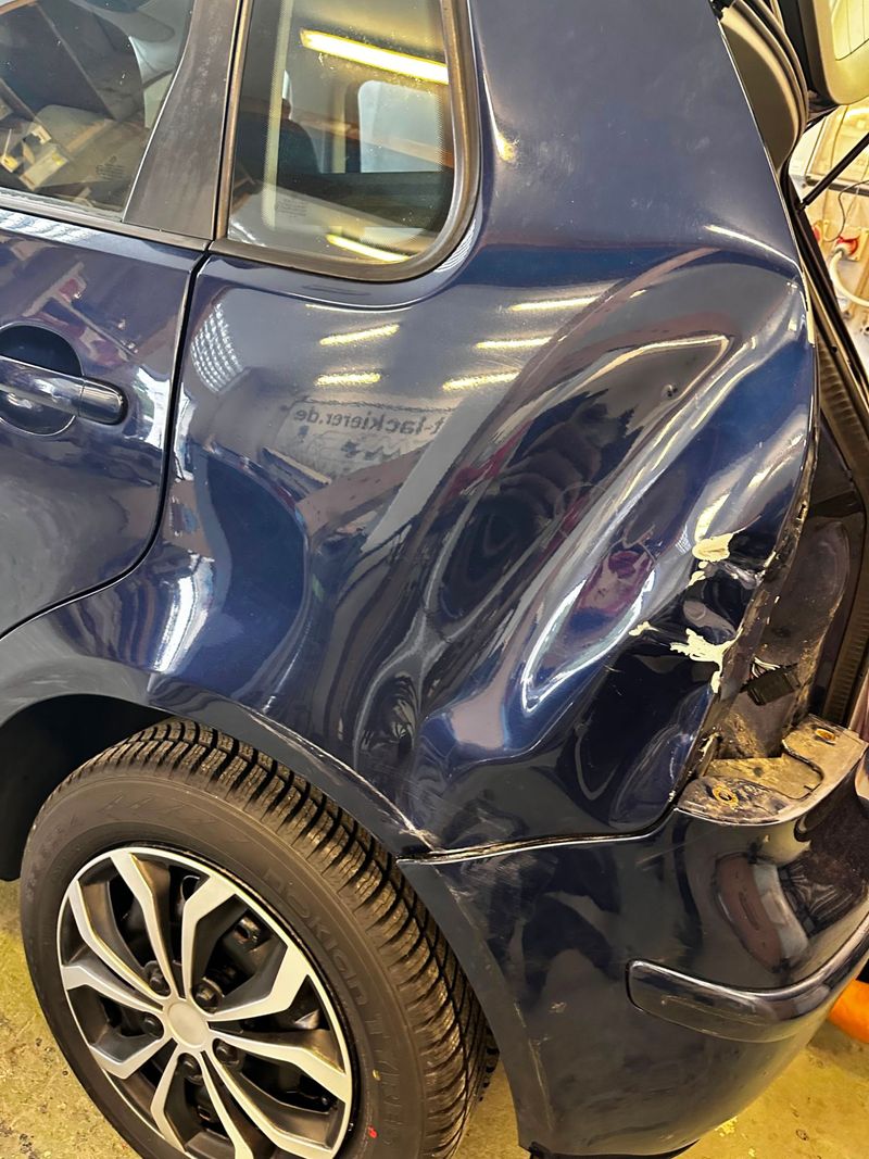 VW Polo mit großflächiger Delle im hinteren Seitenteil vor der Reparatur